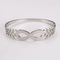 Macro detail of silver infinity symbol with frosted texture and hollow Celtic knot patterns - Steel