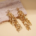 Detailed view of gold leaf tassel drop earrings on a natural stone display base - Gold (Silver Earring Post)