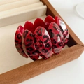 Detail view of a vintage leopard print oval link bracelet on a brown suede jewelry box - Rose Red