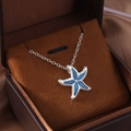 Silver starfish pendant necklace with blue opal inlay in a brown jewelry gift box - Starfish