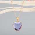 Detalle de un gran colgante de cristal corazón púrpura en una cadena dorada tipo O - Morado