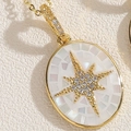 Detalle macro del colgante ovalado dorado con incrustación de nácar y diseño de estrella - Blanco