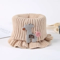 Detail of beige ribbed knit baby scarf with cartoon deer patch and handmade label - Khaki