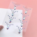 Hand holding iridescent AB rhinestones stickers in teardrop and round shapes for face makeup - Iridescent Teardrop Round Jewels (BJA-704)