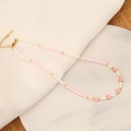 Detail von rosa Herzanhängern an einer weißen Perlenkette mit goldenem Karabinerverschluss - Rosa Kaiserstein (Nr. 7)