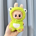 Plush Labubu toy wearing green monster outfit with ears and white belly detail - Green Frog Vest / First And Second Generation Keychains Are Compatible With La Cloth Dolls. Dolls Not Included.