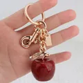 Detailed view of dark red glitter apple keychain with polished gold hardware components - Red Apple with Light Gold