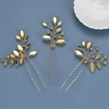 Detailed view of three gold bridal hair pins with crystal leaves on a blue background - KC Gold Hairpins Set of 3 / KC Gold