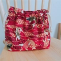 Détail du sac à lunch japonais rouge avec motif de carpe dorée sur une chaise en bois - Poisson Rouge