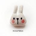 Detail of knitted bunny plush head accessory with embroidery measuring 5.5cm by 4cm - White Rabbit
