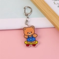 Porte-clés mignon en acrylique avec un ours sur un skateboard jaune et anneau en D - Ours Skateboard