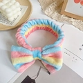 Pink yellow and blue striped coral fleece headband with a large plush bow for skincare - Rainbow Stripes