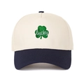 Dettaglio del ricamo a quadrifoglio verde e scritta lucky sul cappello trucker beige - Regolabile / Crema/Blu Navy
