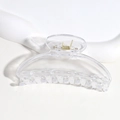 Gros plan d'une pince à cheveux demi-lune en plastique transparent sur fond blanc - Transparent
