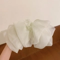 Gros plan d'une barrette à grand nœud en organza blanc avec texture tulle aérienne - Blanc Cassé
