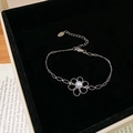 Détail d'un bracelet fleur argenté avec perle blanche dans son écrin en velours noir - Bracelet / Argenté