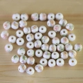 Macro shot of white ceramic beads with pink floral patterns on natural wood surface - No.44-Pink Purple Floral