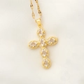 Collar cruz dorada vintage con circonitas brillantes sobre fondo de satén blanco - Dorado
