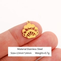 Gold stainless steel fan-shaped shell pendant charm shown on fingertip for scale - Shell-DY1078-2