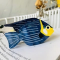 Detailed view of a blue and yellow tropical fish hair claw on a magazine page - Blue Clownfish