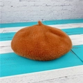 Top view of a soft caramel faux fur beret hat on a textured striped wood surface - M (56-58cm) / Coffee
