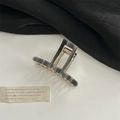 Detailed view of the marble pattern hair claw clip with golden metal spring and teeth - T-shaped Hollow / Grey Marble