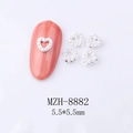 Close-up of 5.5mm silver heart nail charms with white pearls on pink nails - Silver Metal Frame White Pearl (8882)