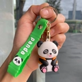 Close-up of cute panda doll keychain with green silicone panda wrist strap on a hand - Bamboo Strap - Basket Panda