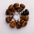 Tiger eye stone gourd shaped pendants with silver metal clasps on a white background - Tiger Eye
