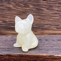 Macro shot of a 3cm white semi-transparent crystal French bulldog figurine on wood - Afghan Jade