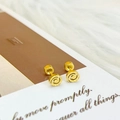 Minimalistische goldene Spiral-Ohrstecker mit matter gebürsteter Oberfläche auf Karte - Mattierter Spiralstil