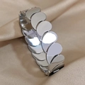 Polished silver tiered teardrop bangle bracelet in stainless steel on silk background - Silver