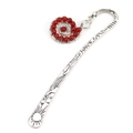 Detailed macro view of retro silver bookmark with sun relief and red bead spiral charm - Silver+Red Agate