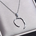 Dettaglio della collana d'argento con pendente irregolare su una scatola regalo in seta - ciondolo collana / Color Acciaio