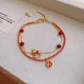 Dettaglio del bracciale dorato a doppio strato con perle rosse e ciondolo a cavallo - Stile Cavallo con Perla Rossa Doppio Strato Placcato in Oro Vero (38#)