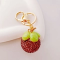 Dettaglio ravvicinato del portachiavi a forma di litchi con strass e finiture dorate - Mangosteen