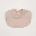 Close-up of soft muslin cotton baby bib in beige color with absorbent fleece lining - Apricot