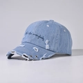 Dettaglio del cappello da baseball in denim azzurro usurato con anelli e ricamo - Regolabile / Blu Denim