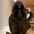Dettaglio di un grande fiocco per capelli in velluto nero con fermaglio in metallo rosa - Camelia con nastro