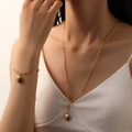Set di gioielli cuore dorato con collana e bracciale a catena su modella elegante - Set Cuore Dorato (Collana + Bracciale)