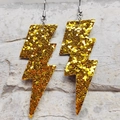 Orecchini a fulmine glitterati dorati con ganci argentati su sfondo di pietra grigia - Glitter Giallo