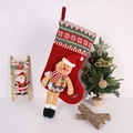 Close-up of a gingerbread man Christmas stocking with snowflake knit trim on a wood ladder - Red Hat Long Leg Gingerbread Man Christmas Stocking