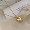 Vista macro di una collana a cuore dorata con diamanti scintillanti e catena a sfere - Argento 925 / Oro