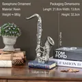 Ornamento sax retrò in resina su base libro blu per decorazione casa e mobile bar - Oro