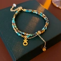 Detail of double-layer turquoise beaded bracelet with gold charms on a luxury gift box - Turquoise Color (HB2803)