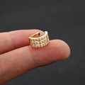 Macro shot of gold ear cuff with three rows of sparkling zircons held by hand - Size 8 / Gold