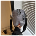 Detail view of a gray Oxford cloth crossbody bag featuring a Hello Weekend label and rope zipper - Gray