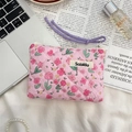 Flat lay of floral quilted storage bag with zipper and wrist strap on a stylish desk - Lusi Portrait