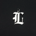 Detailed close-up of a silver Gothic letter L pendant in stainless steel with a metal ring - Letter L