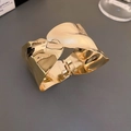 Macro-opname van de 18K vergulde brede golfarmring met een gepolijste textuur - Onregelmatige Rimpeling / Goud